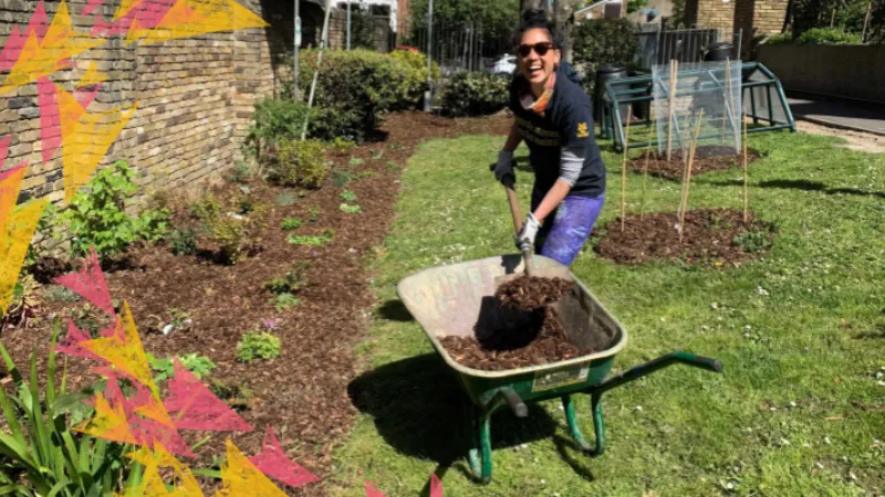 Volunteer gardening and smiling at the camera