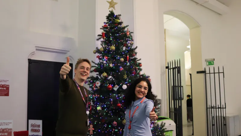 Librarian and student waving a thumbs up