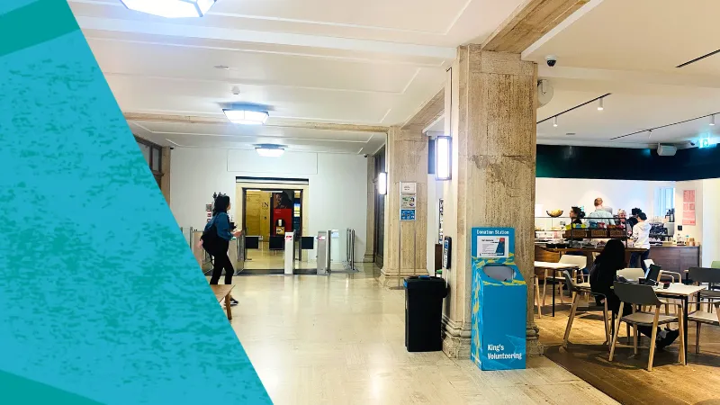 An image of the entrance to Bush House with a blue King's Volunteering donation station in the middle of the image next to a pillar