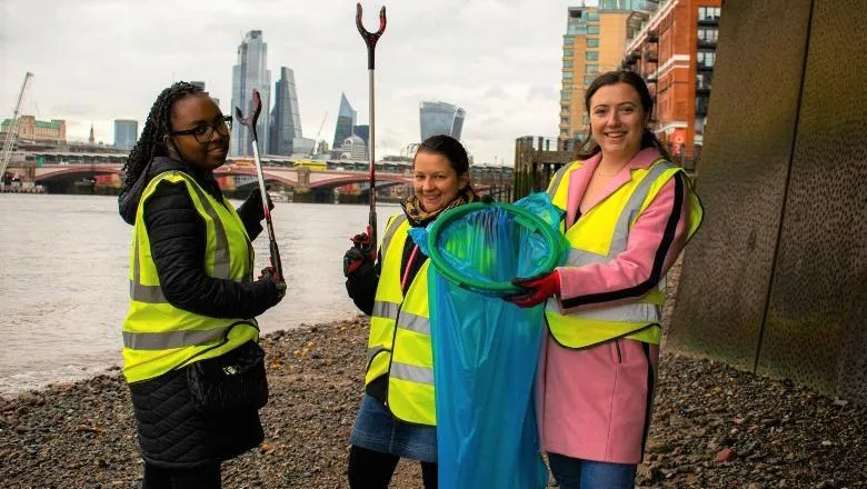 Three volunteers collecting rubbish by the Thames