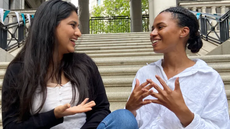 Amna and Rianna talking on the Bush House courtyard steps