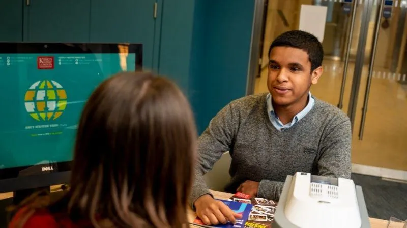 An image of a student sat opposite an advisor in front of ra computer screen