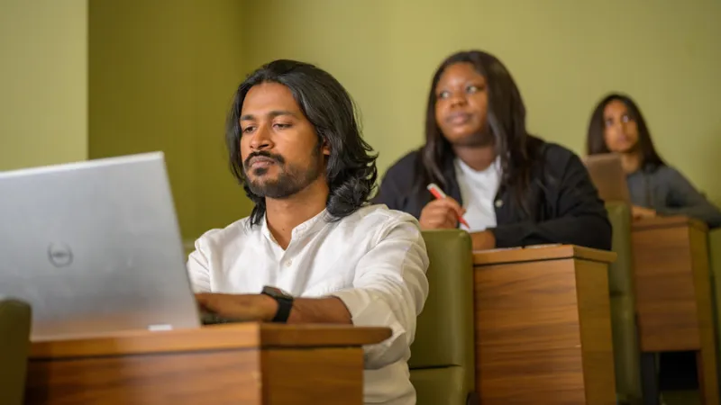 Three students from Black and minoritised ethnic groups in a lecture theatre