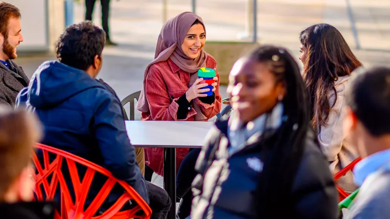 An image of students sat outside drinking coffee