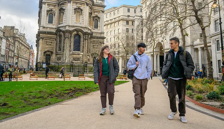 Three students walking and chatting on the Strand campus