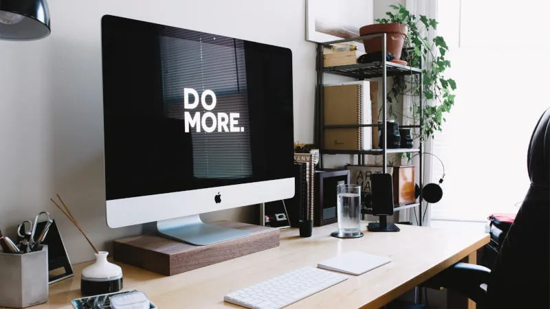 A modern office space with a large monitor displaying the supposedly aspirational phrase 