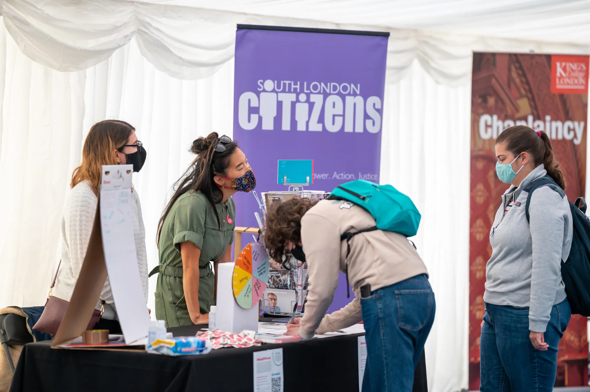 students wearing face coverings chat about volunteering opportunities