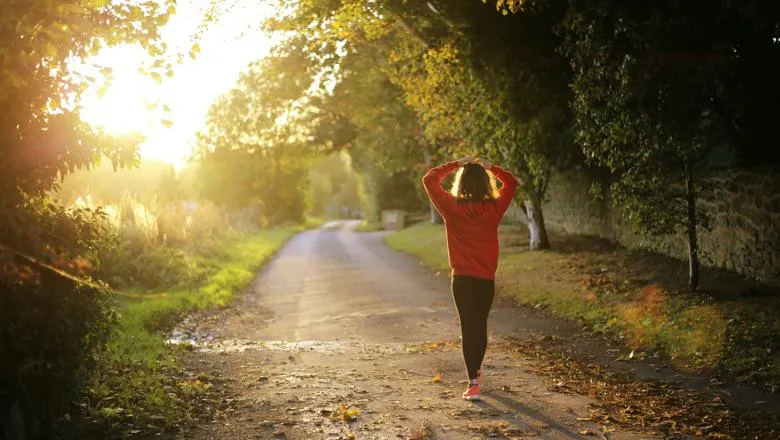 A person walking in a park on a sunny day.