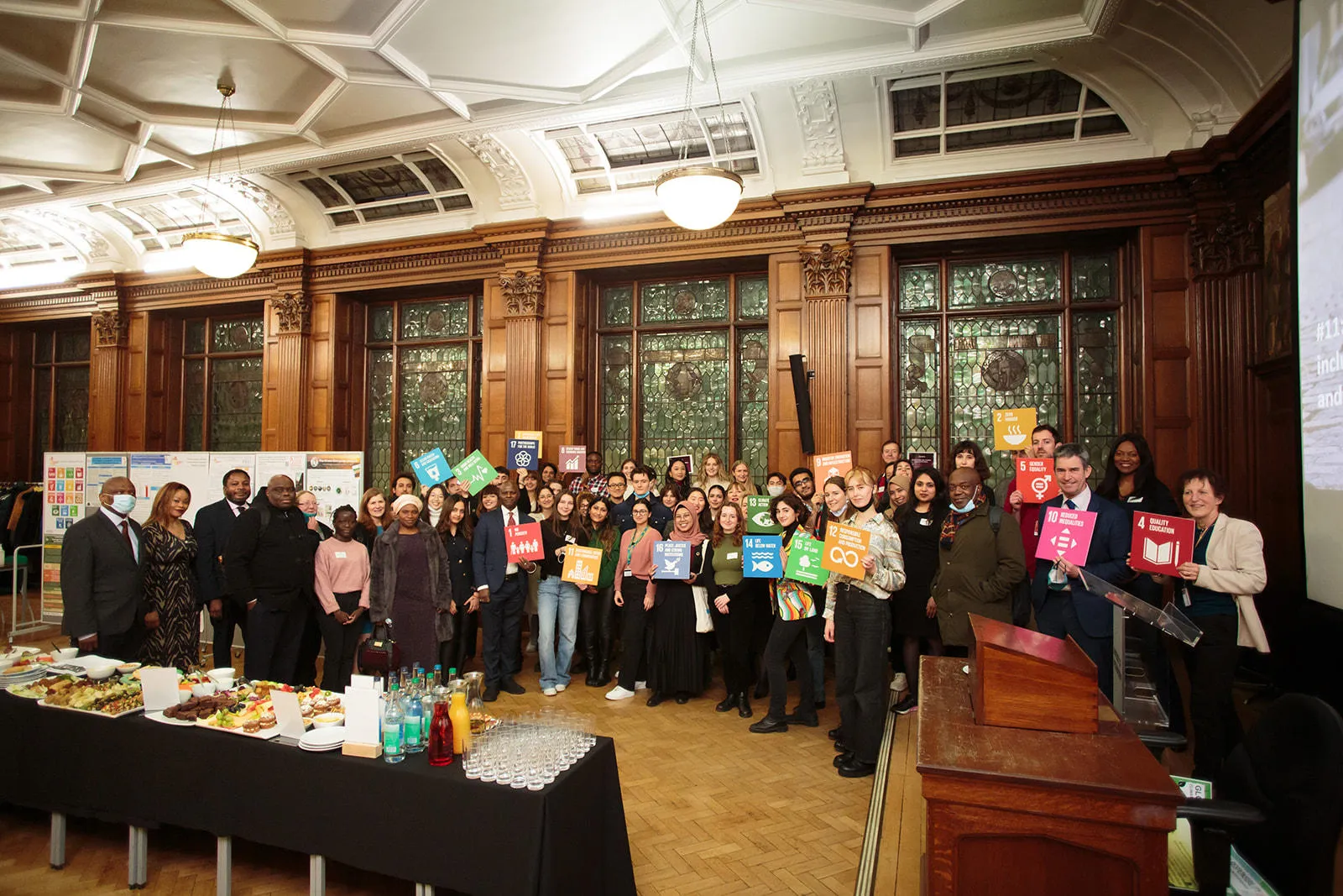 Conference participants holding up SDG icons.