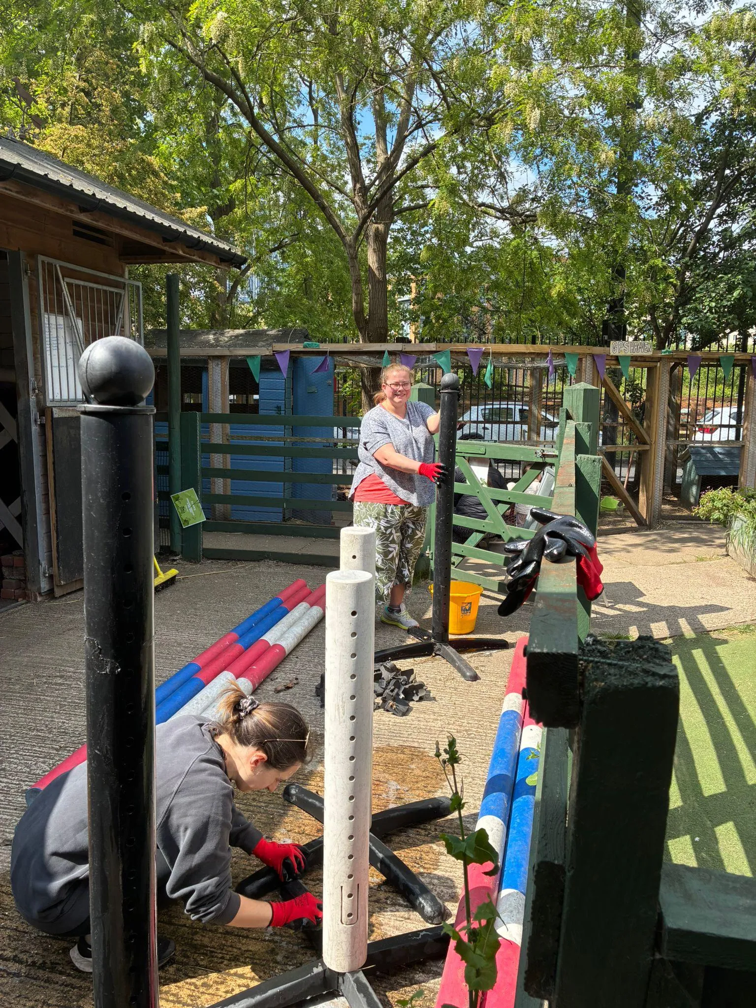 Two women cleaning horse showjumping equipment