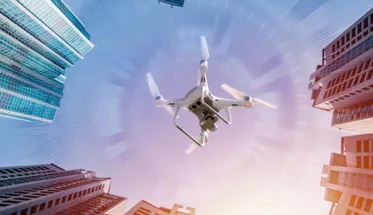 Drone flying in between high-rise buildings