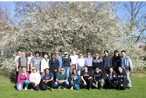 Volunteers standing in front of a hawthorn in full bloom.