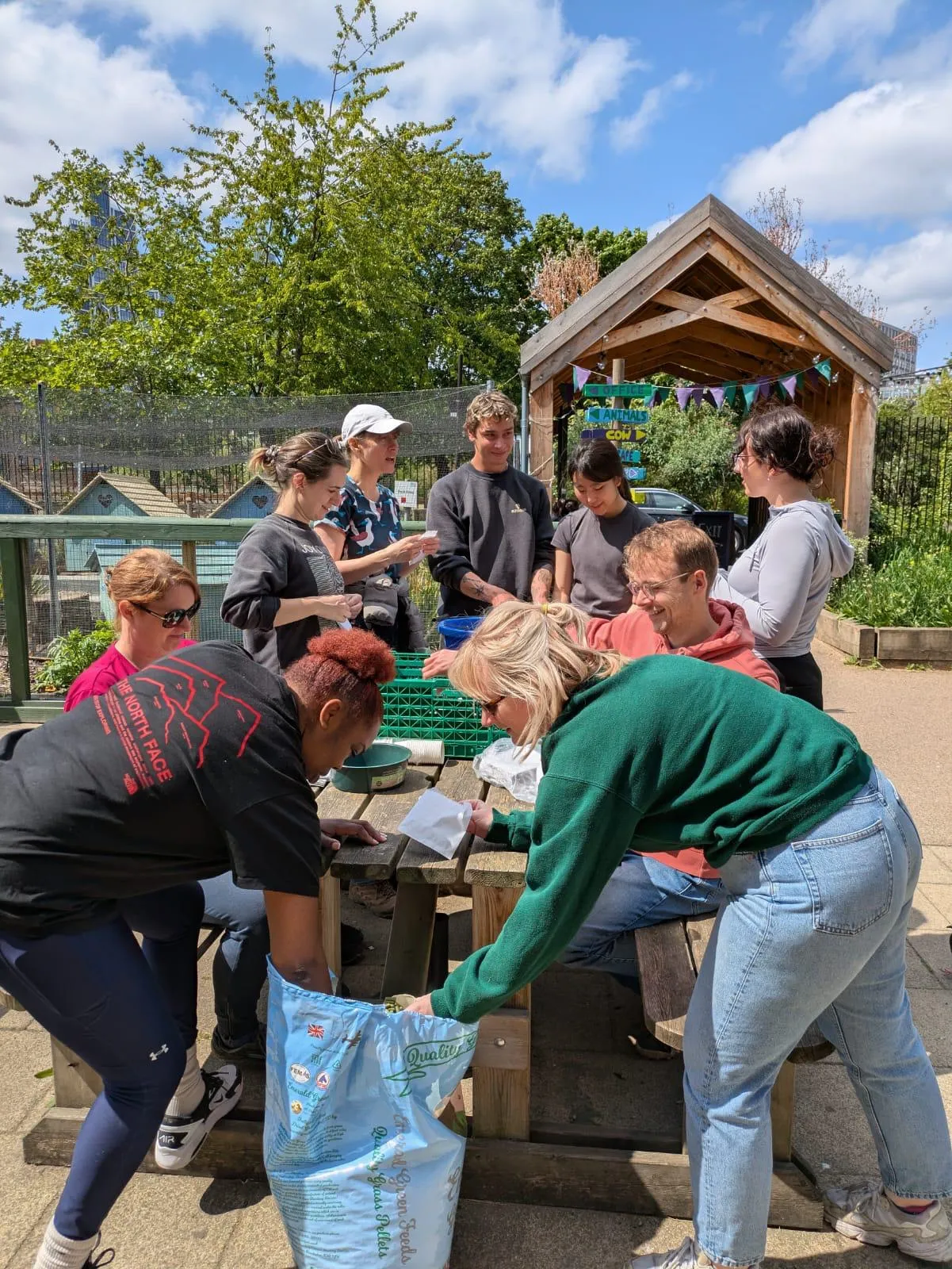 The King's Climate & Sustainability and Estates & Facilities sustainability teams filling food pellet bags for goats