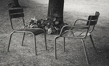 Empty chairs facing one another in a garden