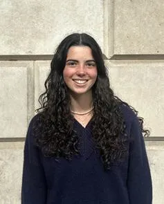 Rita Caseiro smiles and wears a navy jumper 