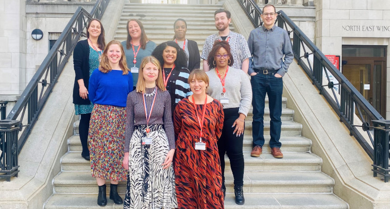 The King's Student Wellbeing Team gathered together on an outdoor stone staircase at Bush House