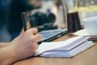 Close-up image of someone writing in a notebook